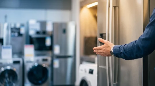 Conseiller en magasin d'électroménager expliquant un appareil à un client, symbolisant la transformation des caractéristiques techniques en argument de vente